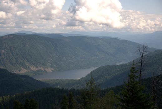 Beautiful view of the valley with a mountain lake from the top of the hill. Altai, Siberia, Russia.