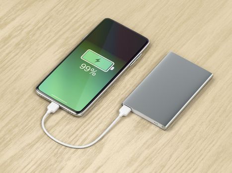 Charging the smartphone with a power bank on wood background