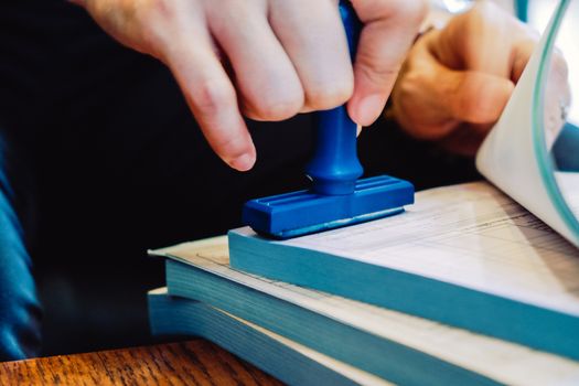 Close-up hand stamping rubber Stamp on a documents, business concept