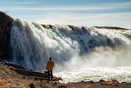 Woman looking at Faxafoss waterfall in a sunny day, Iceland