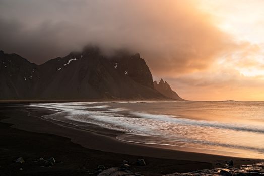 Vestrahorn mountain and the black beach at sunrise in a cloudy day, Iceland