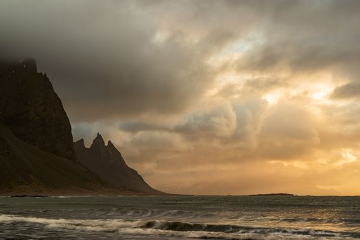 Vestrahorn mountain and ocean at sunrise in a cloudy day, Iceland