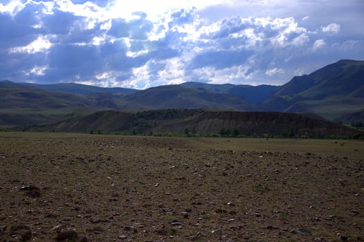 Desert steppe with high hills overgrown with sparse shrubs. Chagan-Uzun, Altai, Russia.