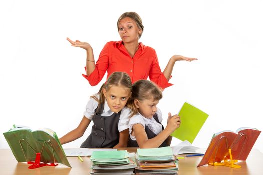 Two girls are pushing while sitting at a desk, the teacher does not know what to do with it