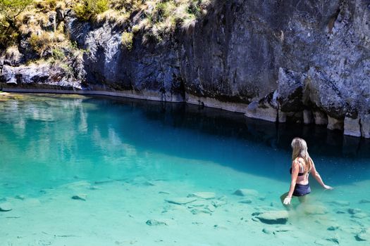 Woman enjoying the cool waters from the limestone caves that have a high calcium carbonate content, which gives their colouring.