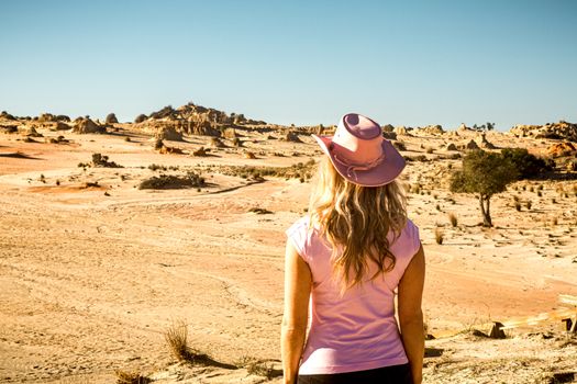 A female viisitor looking out to the Mungo Lunette in the desert of outback Australia.  A series of weathered formations after the lake dried up that are a mixture of sand and clay.