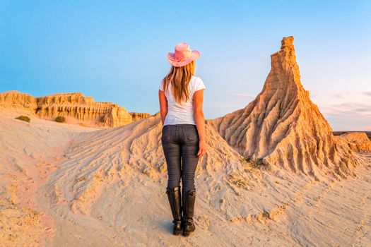 A female tourist walks among the landforms of the lunette at Mungo National Park in the outback desert of Australia