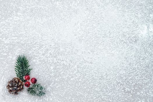 Christmas tree branch, cones and red berries on snowy ice - blank for greeting card or other design, place for text, copy space.