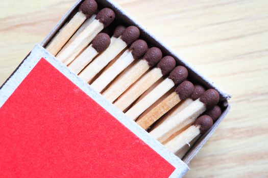 Extreme closeup of open cardboard matchbox on wooden background