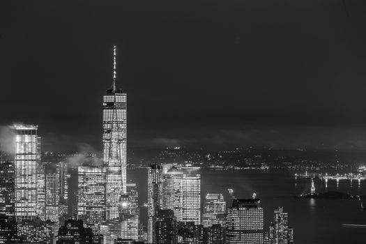 New York City skyline with lower Manhattan skyscrapers in storm at night. Black and white image.