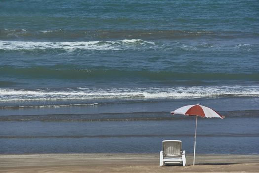 Umbrella and sunbed at the beach landscape with a great blue sky