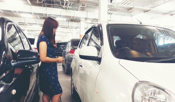 asian woman use key to open or lock her car