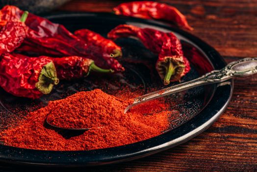 Ground and dried red chili peppers on metal tray