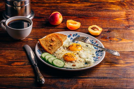 Breakfast toast with fried eggs with vegetables on plate and cup of coffee with fruits over dark wooden background. Healthy, clean eating, dieting food concept.