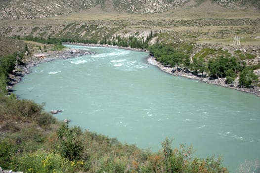 A turquoise river flowing between mountains and a picturesque valley. Katun, Altai, Russia.