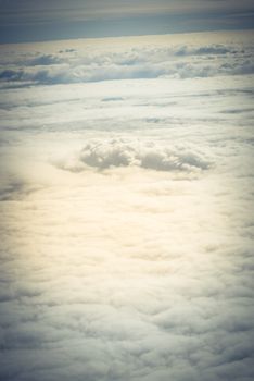 Beautiful and unusual Altocumulus or Cirrocumulus cloud formation seen from airplane window at sunrise. Skyline view above the clouds from the air