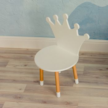 children's chair with a back in the form of a crown in the interior of a bright room