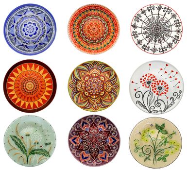 Set of decorative ceramic dishes hand-painted with acrylic paints floral pattern isolated on white background.