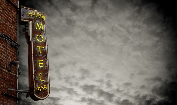 A Grungy Old Neon Motel Sign Against A Stormy Sky With Copy Space