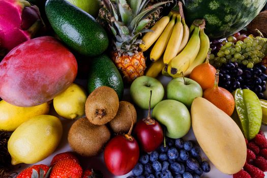 Assorted background of many tropical colorful fruits harvest