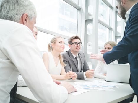 Group of business people discussing diagrams in office together