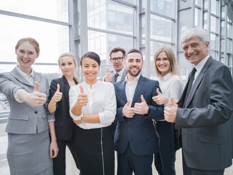 Portrait business people team showing thumbs up , office staff standing in lobby