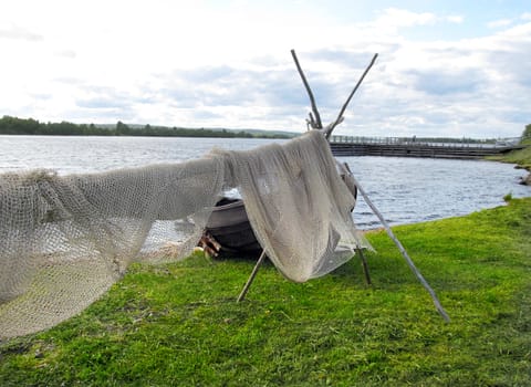
After fishing, the nets are hung on wooden bars,
 
to dry in the wind on the shore of the blue lake.