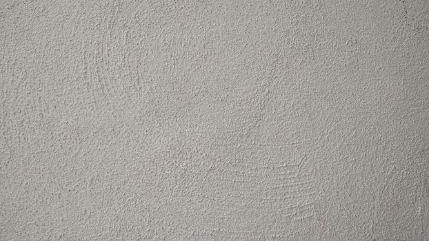 A fragment of a wall in stucco painted in gray.