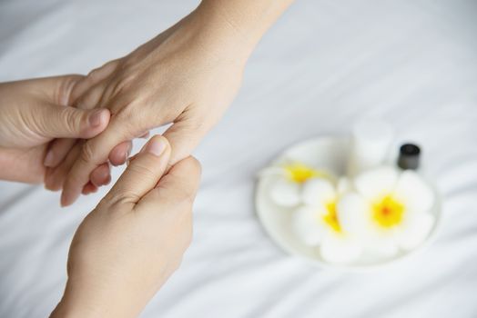 Hand spa massage over clean white bed background - people relax with hand massage service