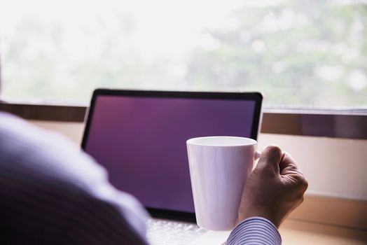 Businessman working with computer with coffee cup in the hotel room - people working lifestyle concept