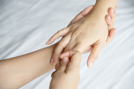 Hand spa massage over clean white bed background - people relax with hand massage service