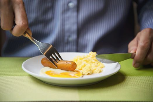 Business man eat the American breakfast set in a hotel - people take a breakfast in hotel concept