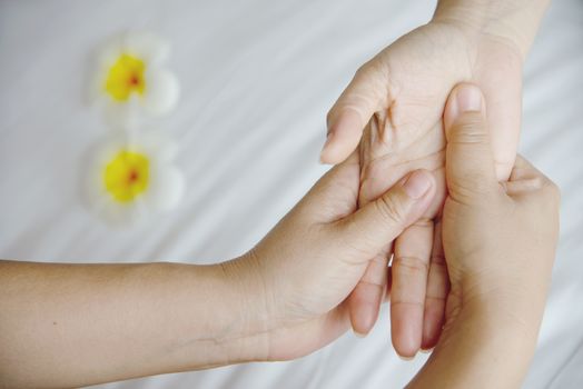 Hand spa massage over clean white bed background - people relax with hand massage service