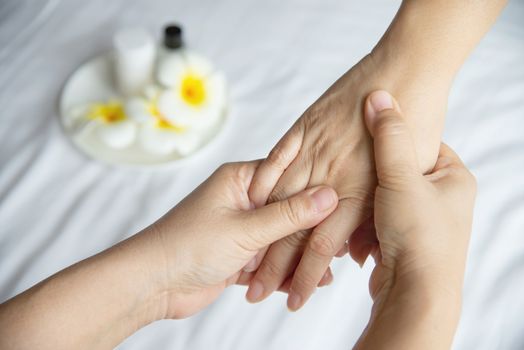 Hand spa massage over clean white bed background - people relax with hand massage service