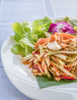 Traditional thai cuisine spicy green papaya salad with salted egg