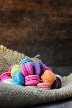 colorful of macarons on a sack over wooden table