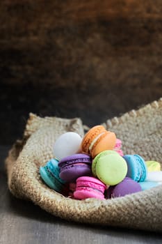 colorful of macarons on a sack over wooden table