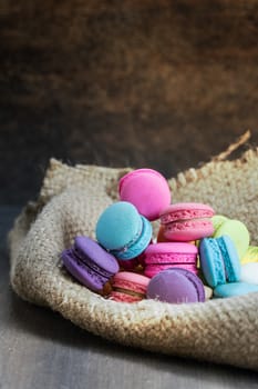 colorful of macarons on a sack over wooden table
