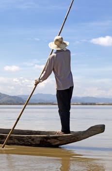 Dak Lak, VIETNAM - JANUARY 6, 2015 - Man pushing a boat with a long pole