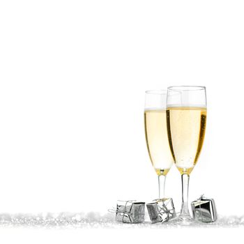 Glasses of champagne and silver gifts on glitter background