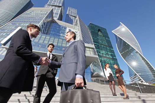 Business people shaking hands, finishing up a meeting outside office