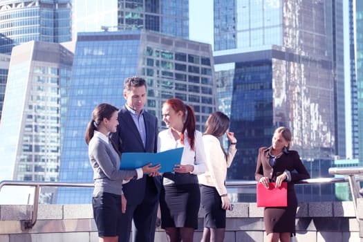 Portrait of business team outside office on skyscrapers background