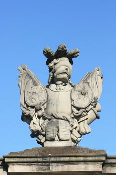 Imaginative sculpture made of gray stone, with blue sky background    Phantasievolle Statue aus grauem Stein,mit blauem Himmel im Hintergrund