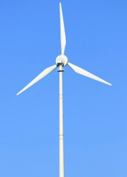 Wind turbine to generate electricity with blue sky in the background  Windrad zur Stromerzeugung mit blauem Himmel im Hintergrund