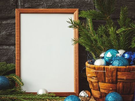 Christmas composition - a wooden frame for text and a basket with fir branches and decorations.