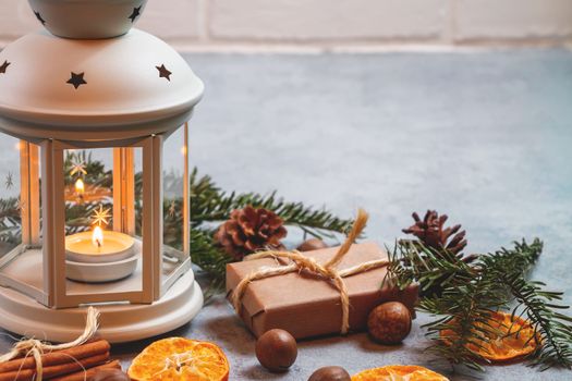 Christmas composition - lantern with burning candle and traditional ornaments.