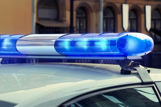 Blue signal lights on the roof of a police patrol car.