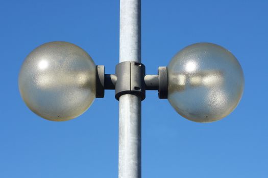 Street light with two lamps, blue sky in the background  Stra�enlaterne mit zwei Strahlern,blauer Himmel im Hintergrund