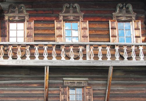 Windows and shutters of an old house made of pine logs.
