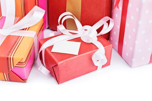 Close-up shot of gift boxes with a greeting card, isolated on white background.